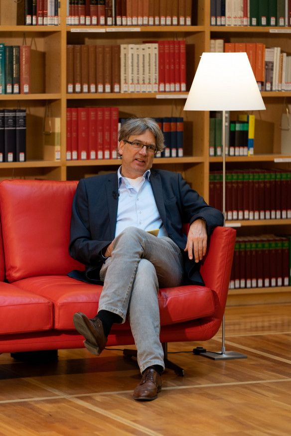 Bibliotheksdirektor Reinhard Laube auf dem Roten Sofa im Bücherkubus